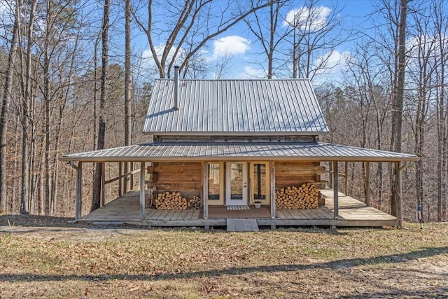 exterior space with metal roof and a view of trees