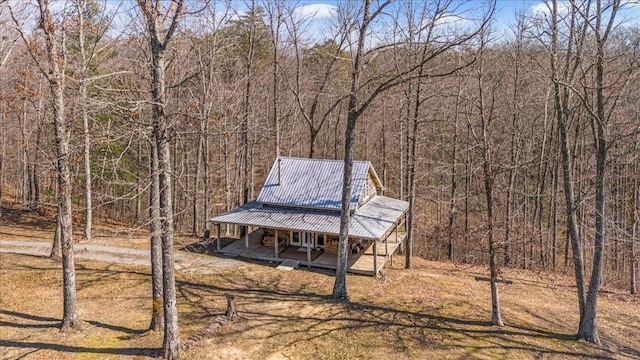 exterior space with a porch and a view of trees