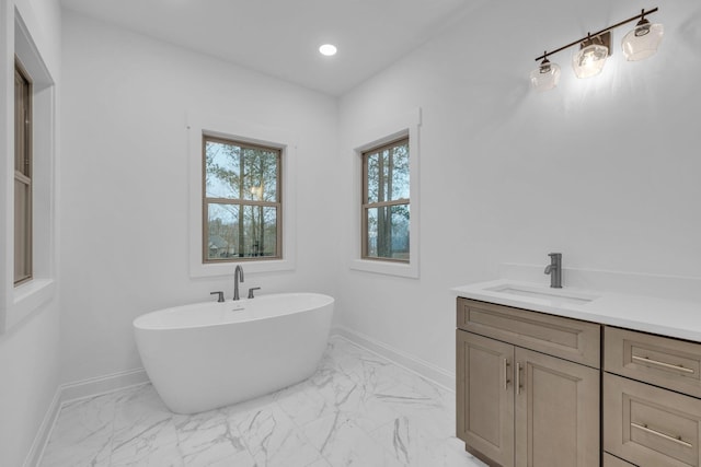 full bath featuring a soaking tub, recessed lighting, vanity, and baseboards