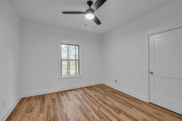 empty room featuring visible vents, baseboards, light wood-type flooring, and a ceiling fan