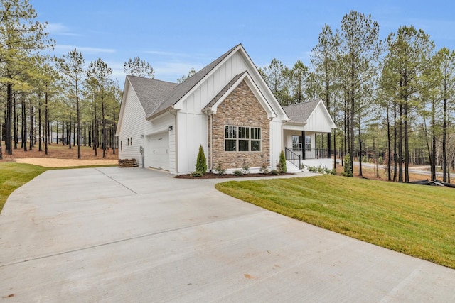 modern farmhouse featuring stone siding, covered porch, board and batten siding, concrete driveway, and a garage