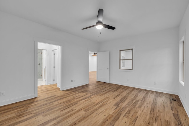 unfurnished bedroom with a ceiling fan, light wood-style floors, baseboards, and ensuite bathroom