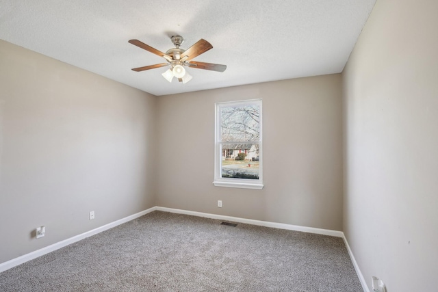 carpeted spare room with visible vents, baseboards, a textured ceiling, and a ceiling fan