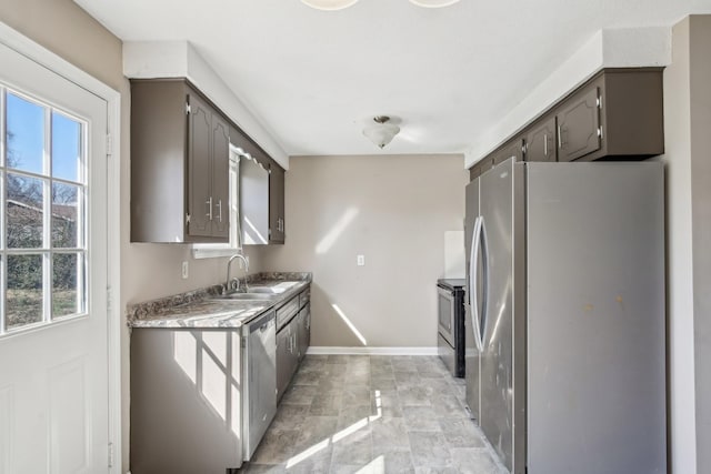 kitchen with gray cabinets, appliances with stainless steel finishes, baseboards, and a sink