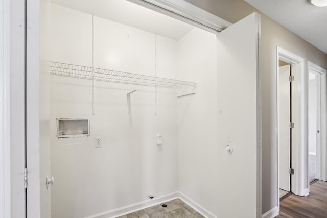 washroom with wood finished floors, baseboards, gas dryer hookup, hookup for a washing machine, and laundry area