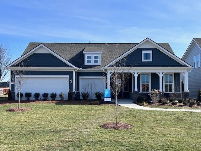 view of front of property with a front yard, covered porch, and a garage