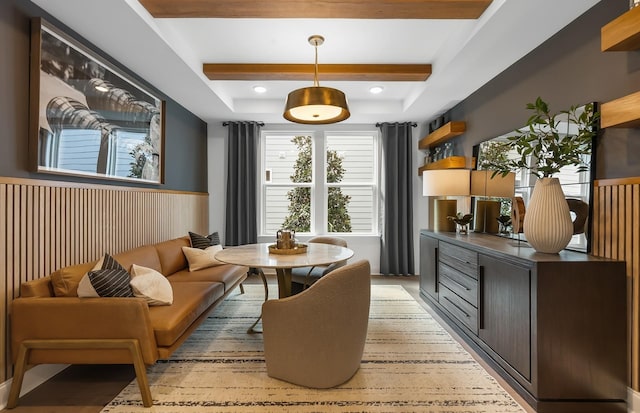 dining room featuring beam ceiling, a wainscoted wall, and a raised ceiling