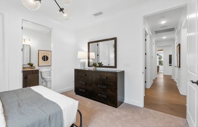 bedroom featuring carpet, visible vents, ensuite bathroom, and baseboards