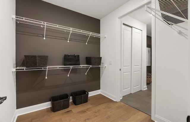 walk in closet with visible vents and wood finished floors