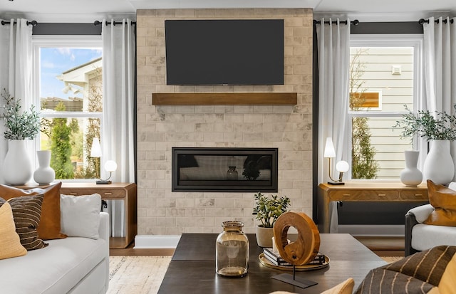 living area featuring a fireplace, wood finished floors, and baseboards