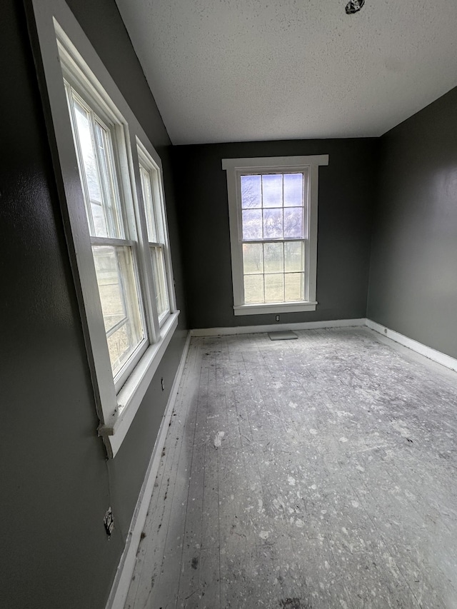 empty room with baseboards and a textured ceiling