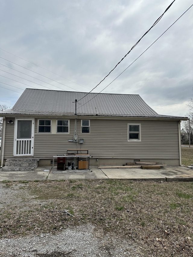 rear view of house featuring metal roof, a patio, and entry steps