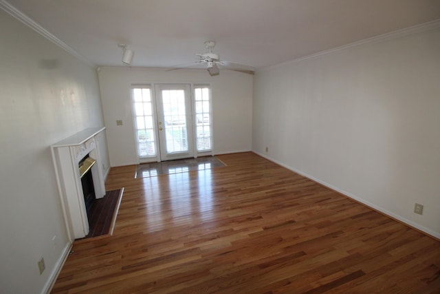 unfurnished living room with wood finished floors, baseboards, a fireplace, ornamental molding, and ceiling fan