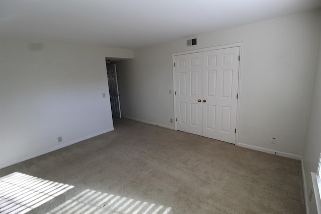 unfurnished bedroom with baseboards, visible vents, carpet floors, and a closet