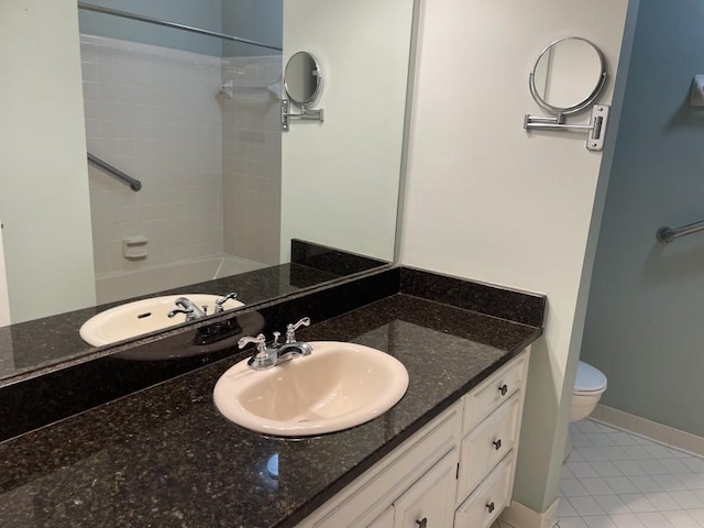 full bath featuring baseboards, toilet, vanity, and tile patterned flooring