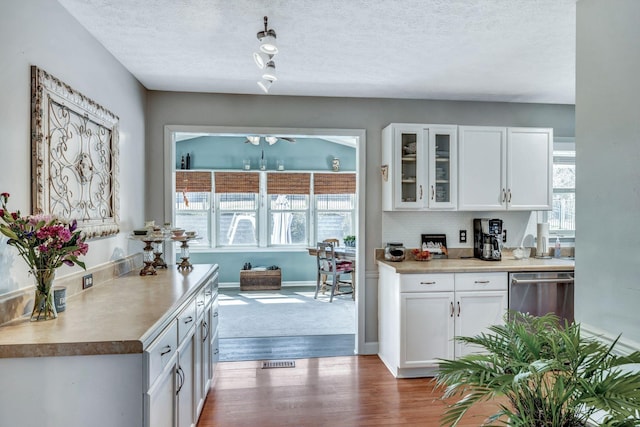 kitchen featuring dark wood-style floors, white cabinets, dishwasher, and glass insert cabinets