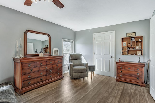 living area with vaulted ceiling, a ceiling fan, and wood finished floors