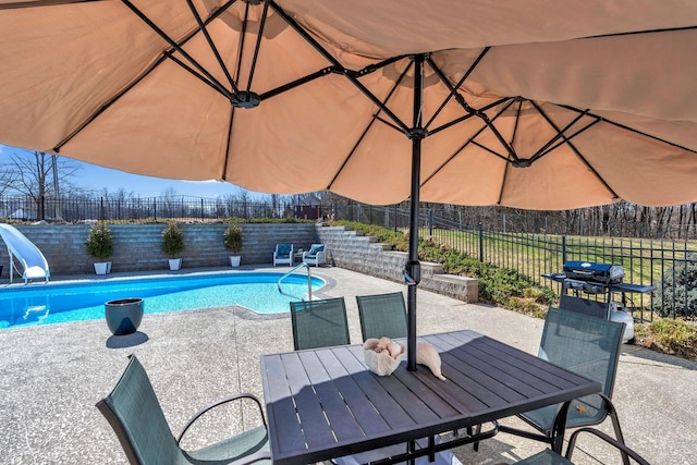 view of pool featuring a patio, a fenced backyard, a water slide, outdoor dining area, and a fenced in pool