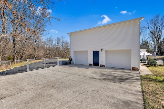 view of property exterior featuring a gate, driveway, and fence