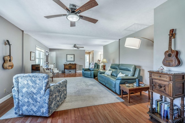 living area featuring visible vents, baseboards, wood finished floors, and a ceiling fan