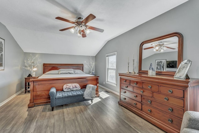 bedroom featuring ceiling fan, baseboards, lofted ceiling, and wood finished floors