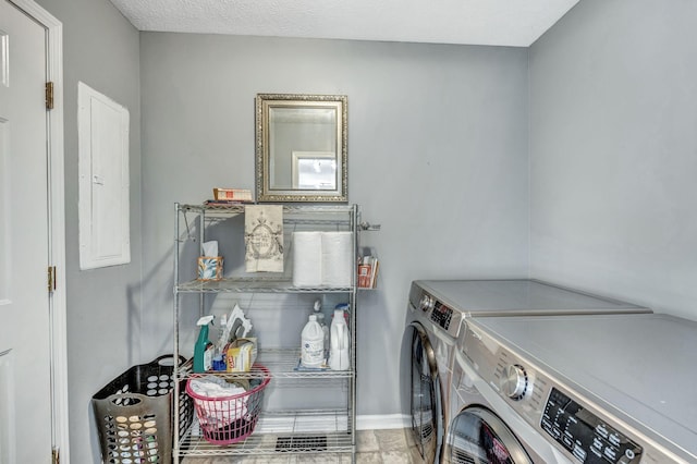 washroom featuring baseboards, washing machine and dryer, electric panel, laundry area, and a textured ceiling