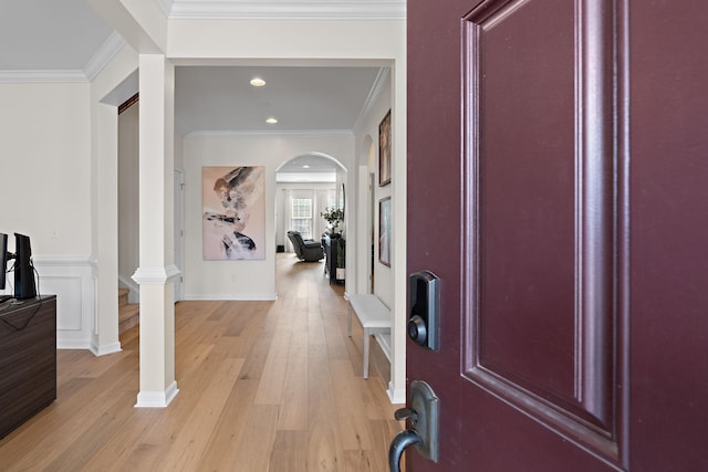 entryway with recessed lighting, arched walkways, crown molding, and light wood finished floors