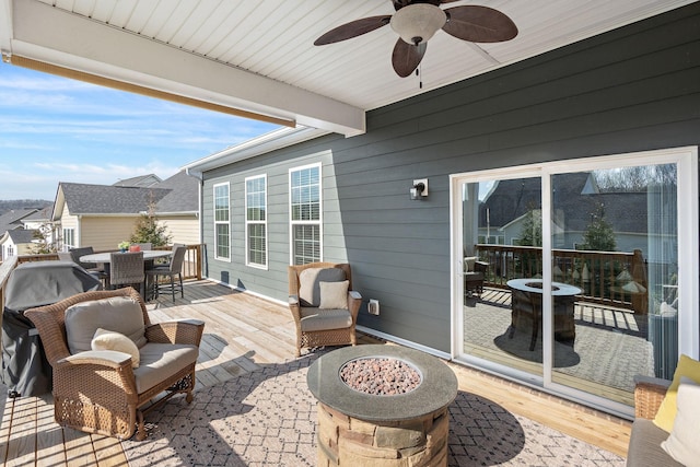 view of patio / terrace featuring a wooden deck, a fire pit, outdoor dining area, and ceiling fan