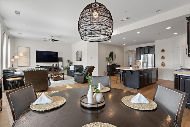 dining space featuring visible vents, ceiling fan, recessed lighting, wood finished floors, and arched walkways