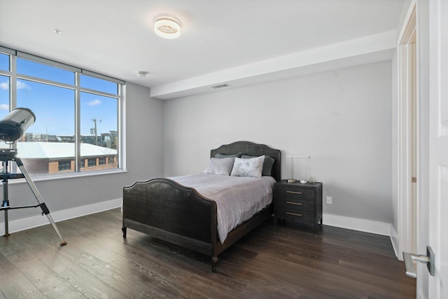 bedroom with visible vents, baseboards, and dark wood-style floors