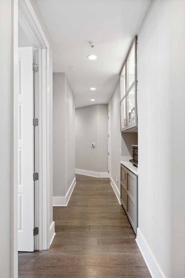 hall featuring recessed lighting, baseboards, and dark wood-style flooring