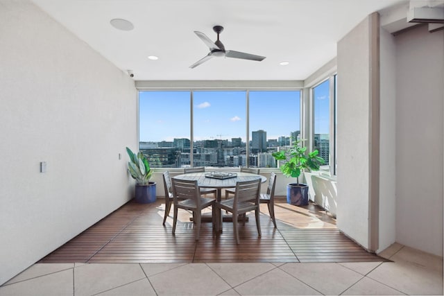 dining space featuring light tile patterned floors, a city view, and ceiling fan