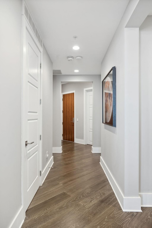 hall with recessed lighting, baseboards, and dark wood-style flooring