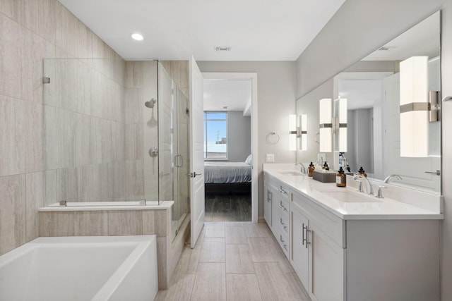 bathroom featuring ensuite bath, a bath, a stall shower, and a sink