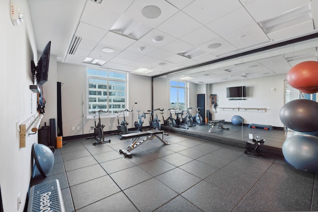 exercise room featuring visible vents, baseboards, and a drop ceiling