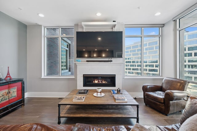 living room featuring a high end fireplace, recessed lighting, baseboards, and wood finished floors