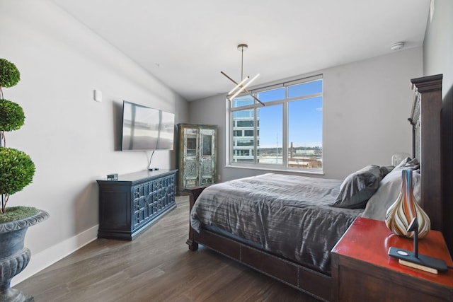 bedroom featuring baseboards, lofted ceiling, and wood finished floors