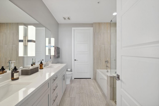 full bathroom with a sink, visible vents, toilet, and double vanity