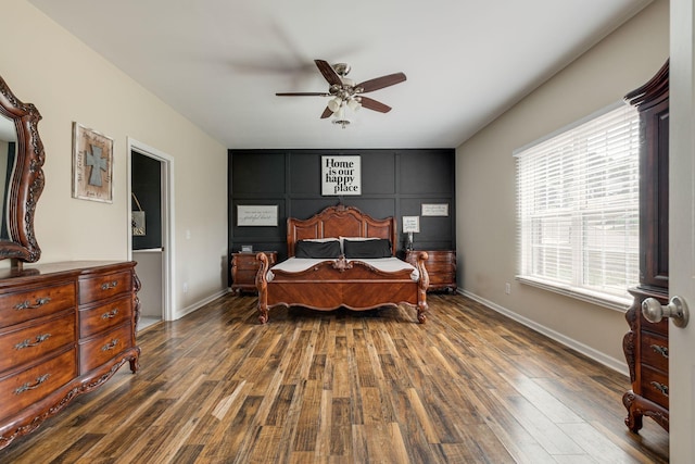 bedroom featuring dark wood-type flooring, a ceiling fan, and baseboards