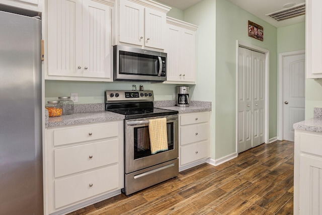 kitchen featuring visible vents, appliances with stainless steel finishes, dark wood-style flooring, and white cabinetry