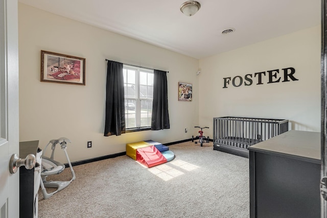 bedroom with a crib, carpet flooring, baseboards, and visible vents