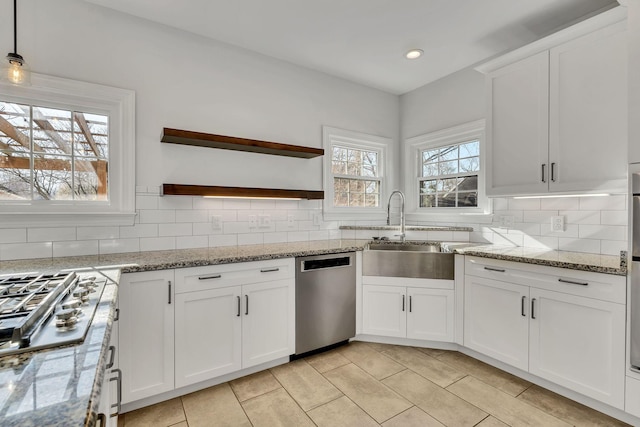 kitchen with open shelves, a sink, appliances with stainless steel finishes, white cabinetry, and backsplash