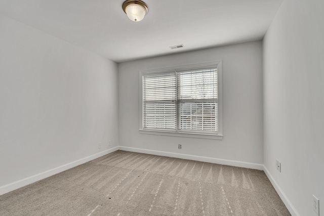 empty room featuring visible vents, baseboards, and carpet flooring