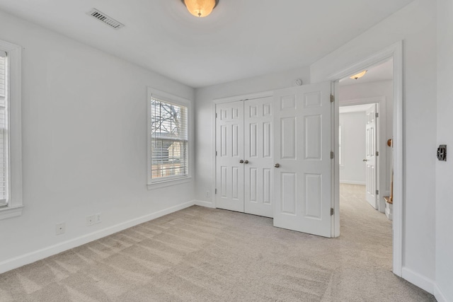 unfurnished bedroom featuring a closet, visible vents, carpet flooring, and baseboards