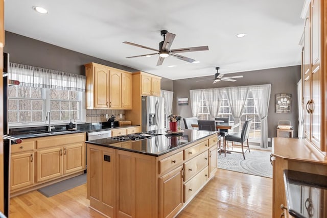 kitchen featuring dishwashing machine, a ceiling fan, light brown cabinets, a sink, and stainless steel refrigerator with ice dispenser