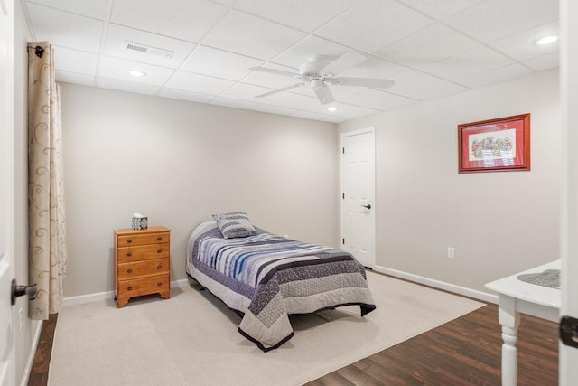 bedroom with visible vents, wood finished floors, a paneled ceiling, baseboards, and ceiling fan