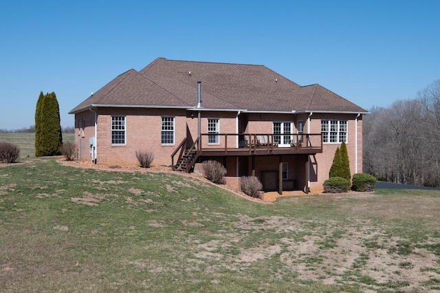 rear view of property featuring brick siding, stairway, a lawn, and a deck