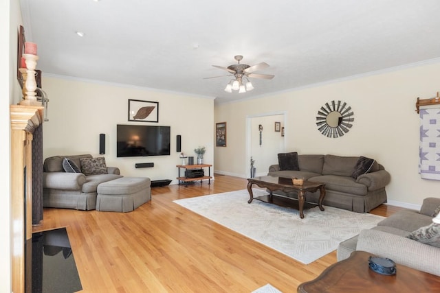 living room with a ceiling fan, wood finished floors, baseboards, and ornamental molding