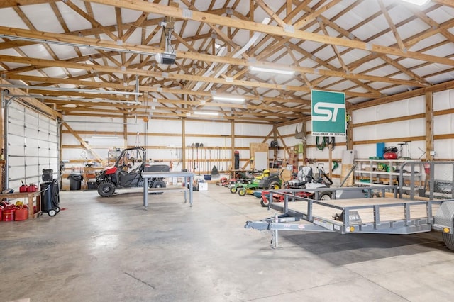 garage with a workshop area, a garage door opener, and metal wall