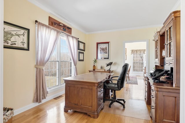 home office featuring crown molding, baseboards, and light wood finished floors